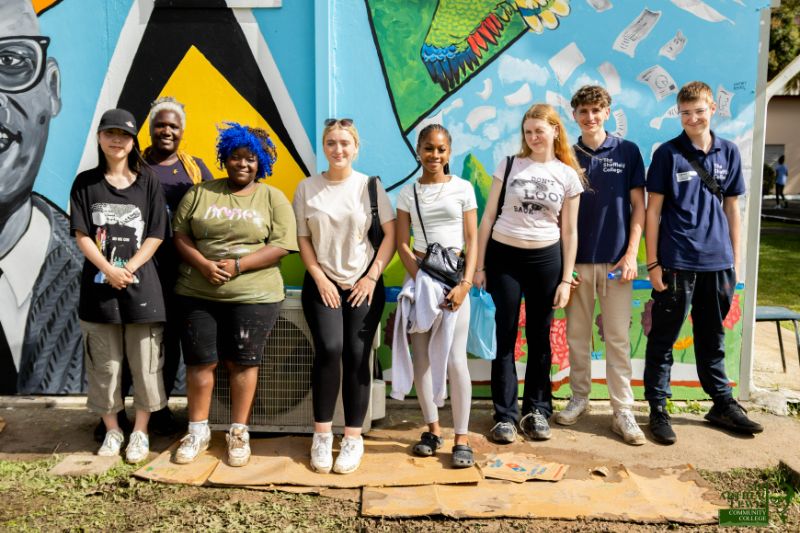 caribbean elective students pose before sir arthur lewis mural